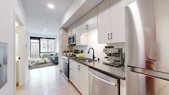 A modern kitchen with stainless steel appliances and white cabinets.