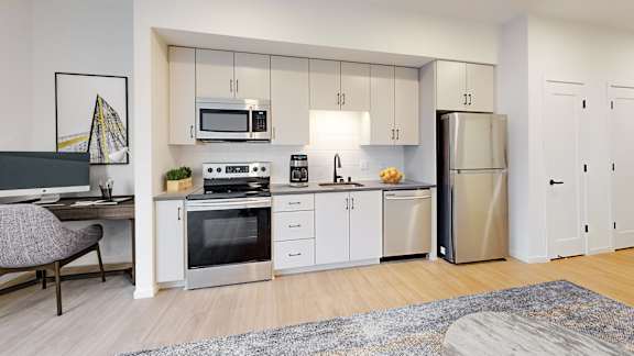 A modern kitchen with stainless steel appliances and white cabinetry.