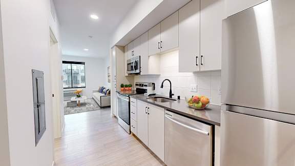 A modern kitchen with stainless steel appliances and white cabinets.