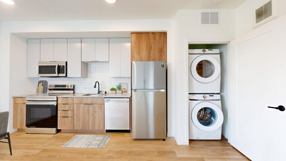 a kitchen with a washing machine and a refrigerator