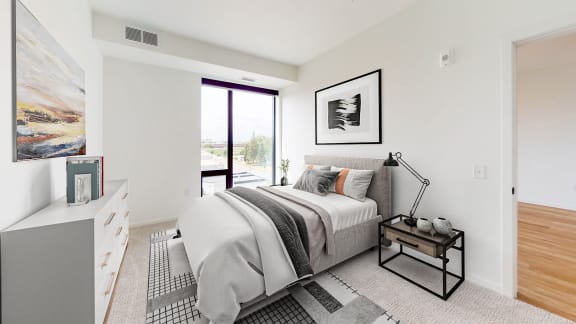 a bedroom with a bed and a large window