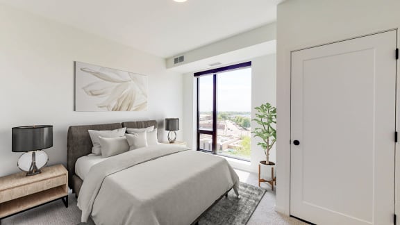a white bedroom with a large bed and a door to a balcony