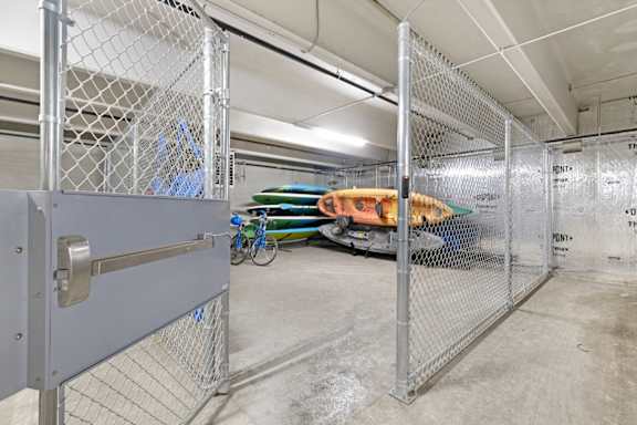 A storage area with a bike and a kayak inside.