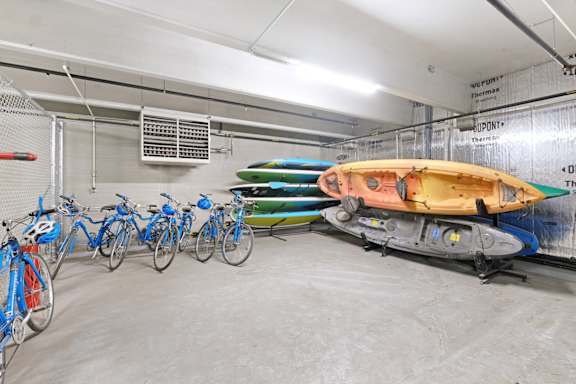 A row of bicycles are parked in a garage.