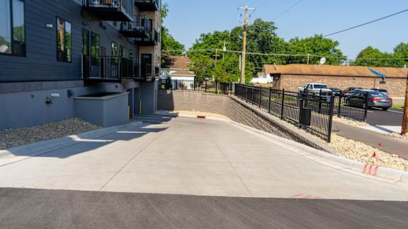 a driveway with a retaining wall in front of a building