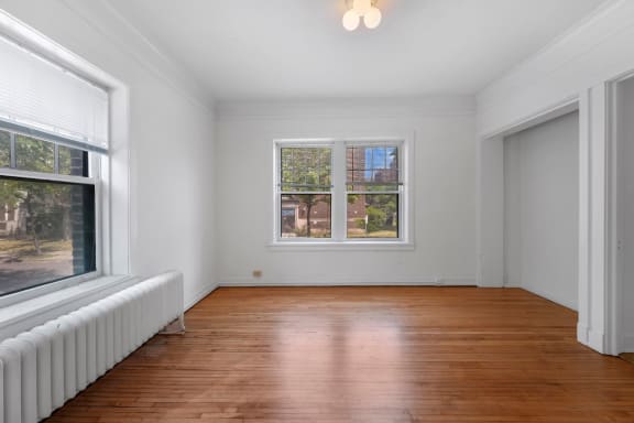 a bedroom with a large window and a radiator on the wall
