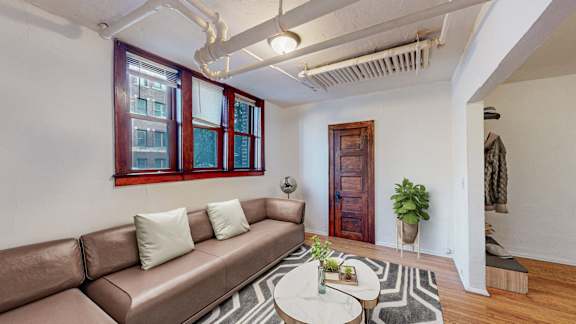 A living room with a brown couch and a white coffee table.