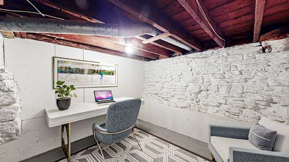 A room with a stone wall and a chair.