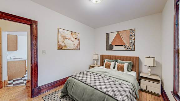 A bedroom with a bed, nightstands, and a painting on the wall.