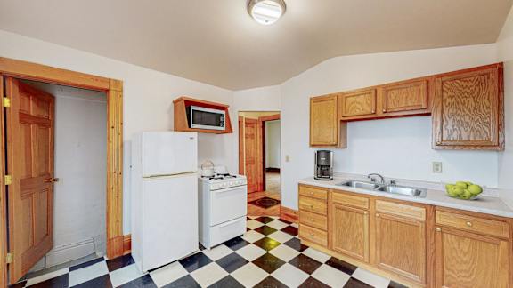 A kitchen with a black and white checkered floor.