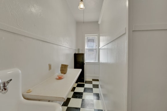 a kitchen with a white counter top and a black and white checkered floor