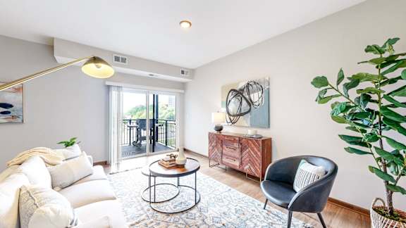 A living room with a white sofa, a black chair, and a round coffee table.