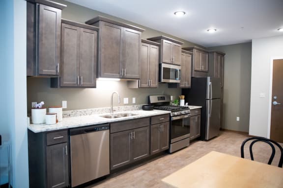 a large kitchen with stainless steel appliances and wooden cabinets