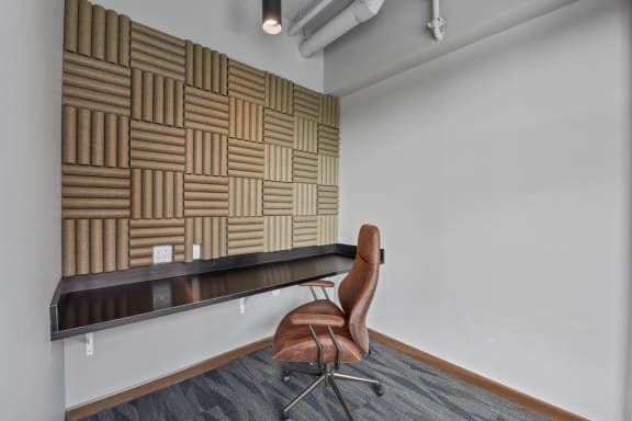 a chair sits in front of a long desk in an office