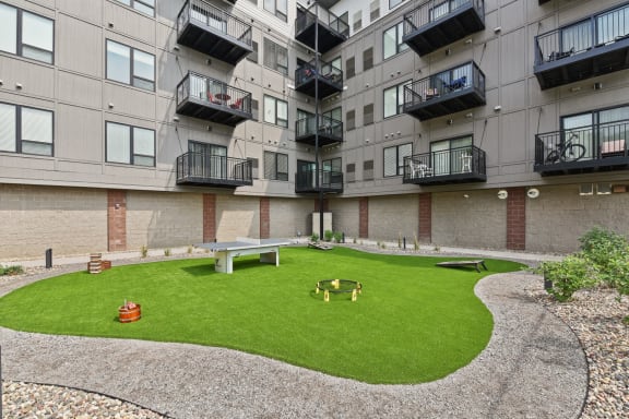 an apartment yard with a picnic table and a fire pit