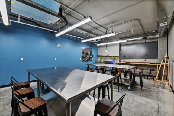 a room with tables and chairs and a chalkboard on the wall