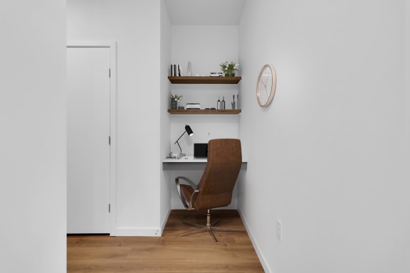 a home office with a desk and a chair and a clock on the wall