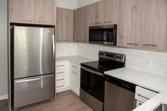 Nordic kitchen with stainless steel, quartz countertops, two-toned cabinets at Urban Park I and II Apartments, St Louis Park, MN, 55426