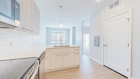 a kitchen with white cabinets and a white door