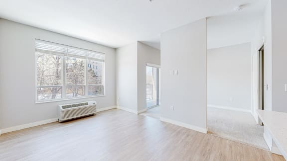 a bedroom with a large window and hardwood floors