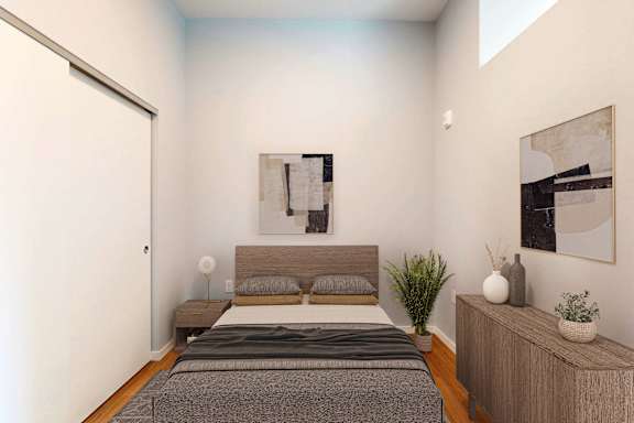 A bedroom with a bed, nightstand, and two framed pictures on the wall.
