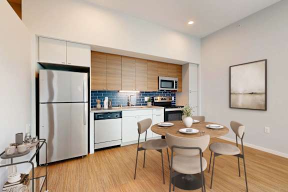 A modern kitchen with a dining table set for four.