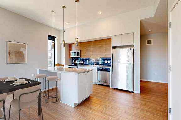 A modern kitchen with a dining table and chairs.