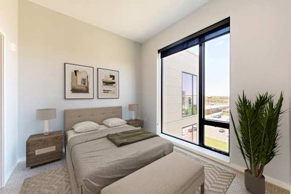 A bedroom with a large bed and a potted plant.