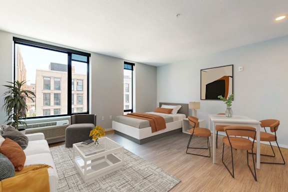 A modern bedroom with a large bed, a couch, a chair, a coffee table, and a painting on the wall.