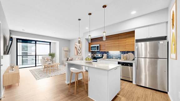 A modern kitchen with a white island and stainless steel appliances.