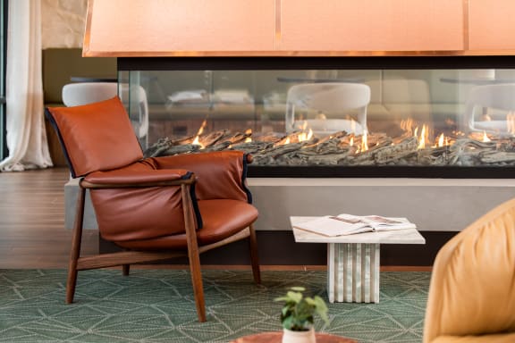 a living room with a fireplace and a leather chair