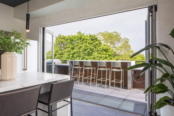 a kitchen with a large window that opens up to a terrace