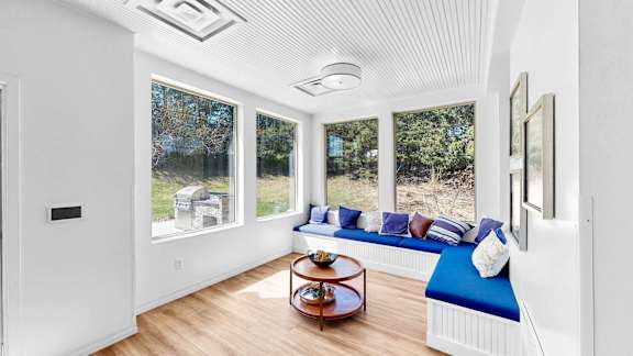 A sunny room with a window seat and a coffee table.