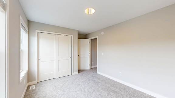 A room with white walls and carpeted floor with a ceiling light.