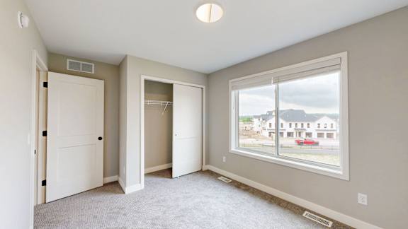 A room with a large window and a view of a building outside.