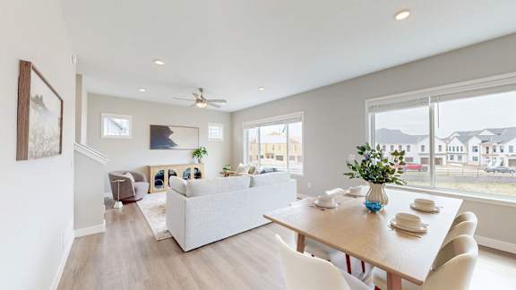 A modern living room with a dining table set for two.