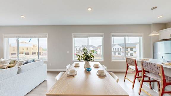 A modern dining room with a long wooden table and chairs.