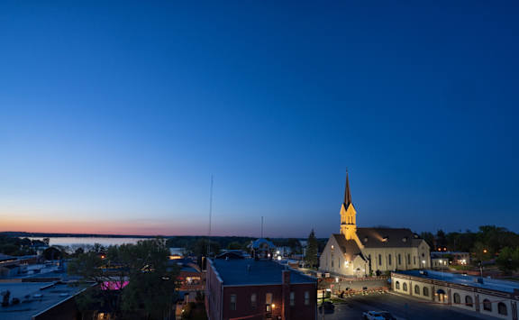 A church with a tall steeple stands out against the evening sky.