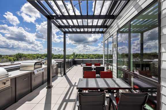 A patio with a table and chairs is covered by a roof.