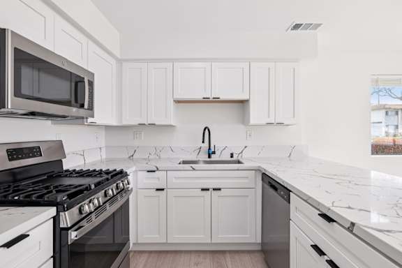 Kitchen with black appliances at Ocean Villas Apartments, Oxnard, CA