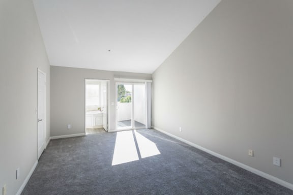 a carpeted living room with white walls and a door to a bathroom at Warner Center Townhomes, Canoga Park, 91303