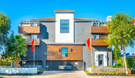a house with two orange flags in front of it at Warner Center Townhomes, California, 91303