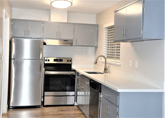 a kitchen with stainless steel appliances and white counter tops at Trailhead Apartments at Tam Junction, Mill Valley, 94941