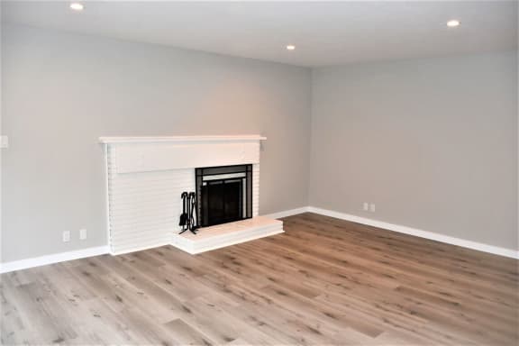 a living room with a fireplace and wooden floors at Trailhead Apartments at Tam Junction, Mill Valley California