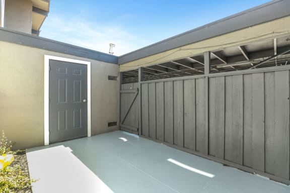 a garage with a gray door and a gray fence  at The Preston at Hillsdale, San Mateo, CA