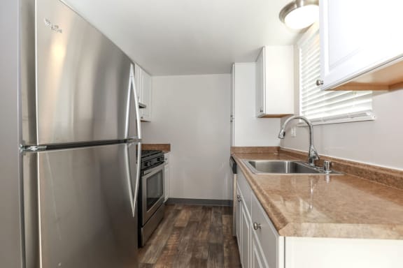 a kitchen with stainless steel appliances and a counter top at The Preston at Hillsdale, San Mateo, 94403