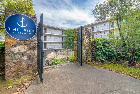 a gate with a blue sign in front of an apartment building at The Pier at Sausalito, California, 94965