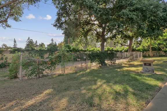 the backyard of a house with a fence and a tree at Summerwood Apartments, Santa Clara, CA