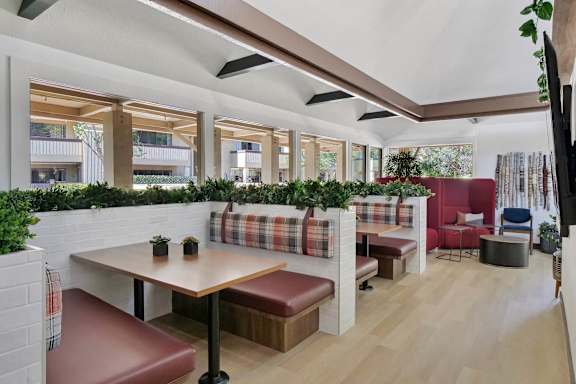 a lobby with red chairs and potted plants at Summerwood Apartments, California, 95050