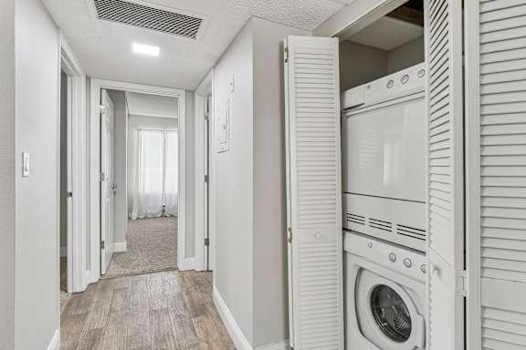 a washer and dryer in a laundry room with a closet at Summerwood Apartments, Santa Clara, California